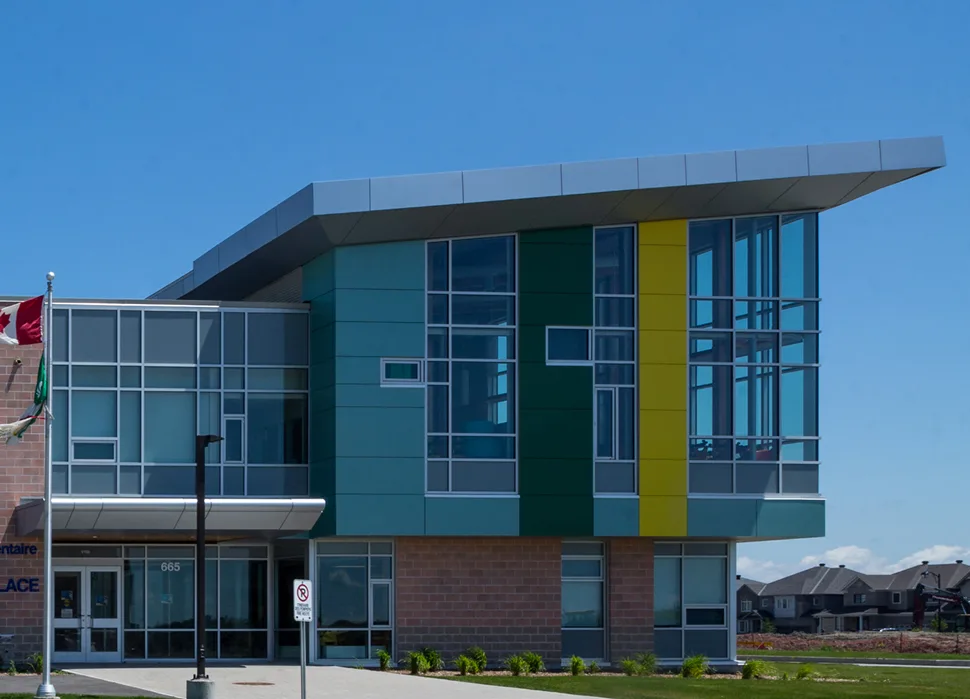 Ecole Notre Place school building featuring a prominent green and yellow facade, completed by TOFCON in Ottawa.
