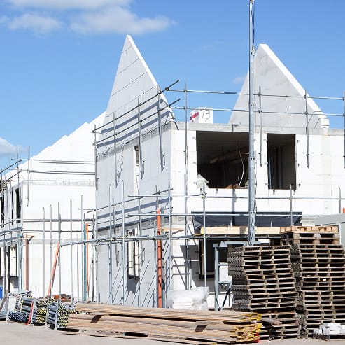 A large building under construction in Ottawa, featuring a prominent crane lifting materials for TOFCON's commercial project.