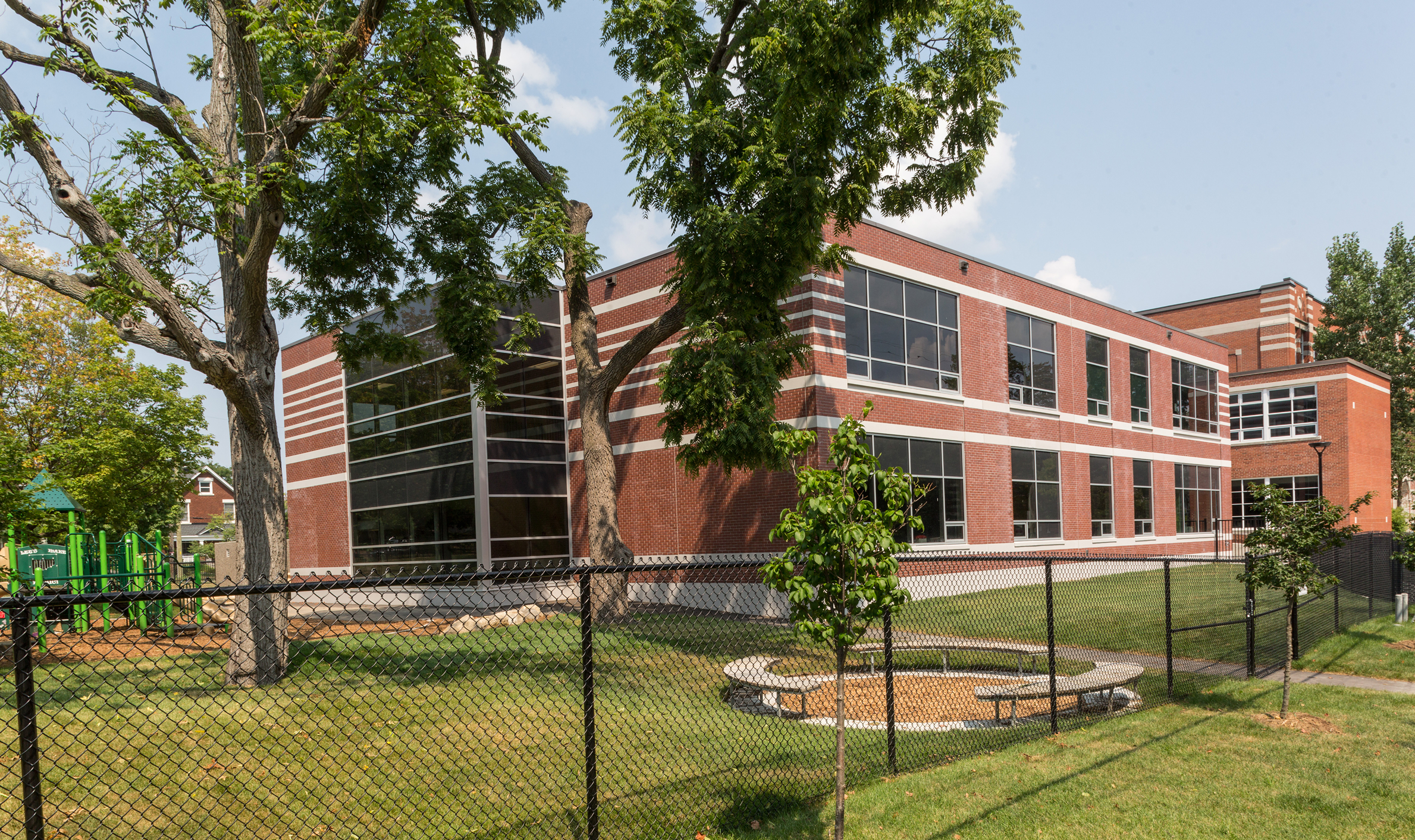 A brick building featuring windows and a fence, representing TOFCON's construction efforts for Elmdale Public School in Ottawa.
