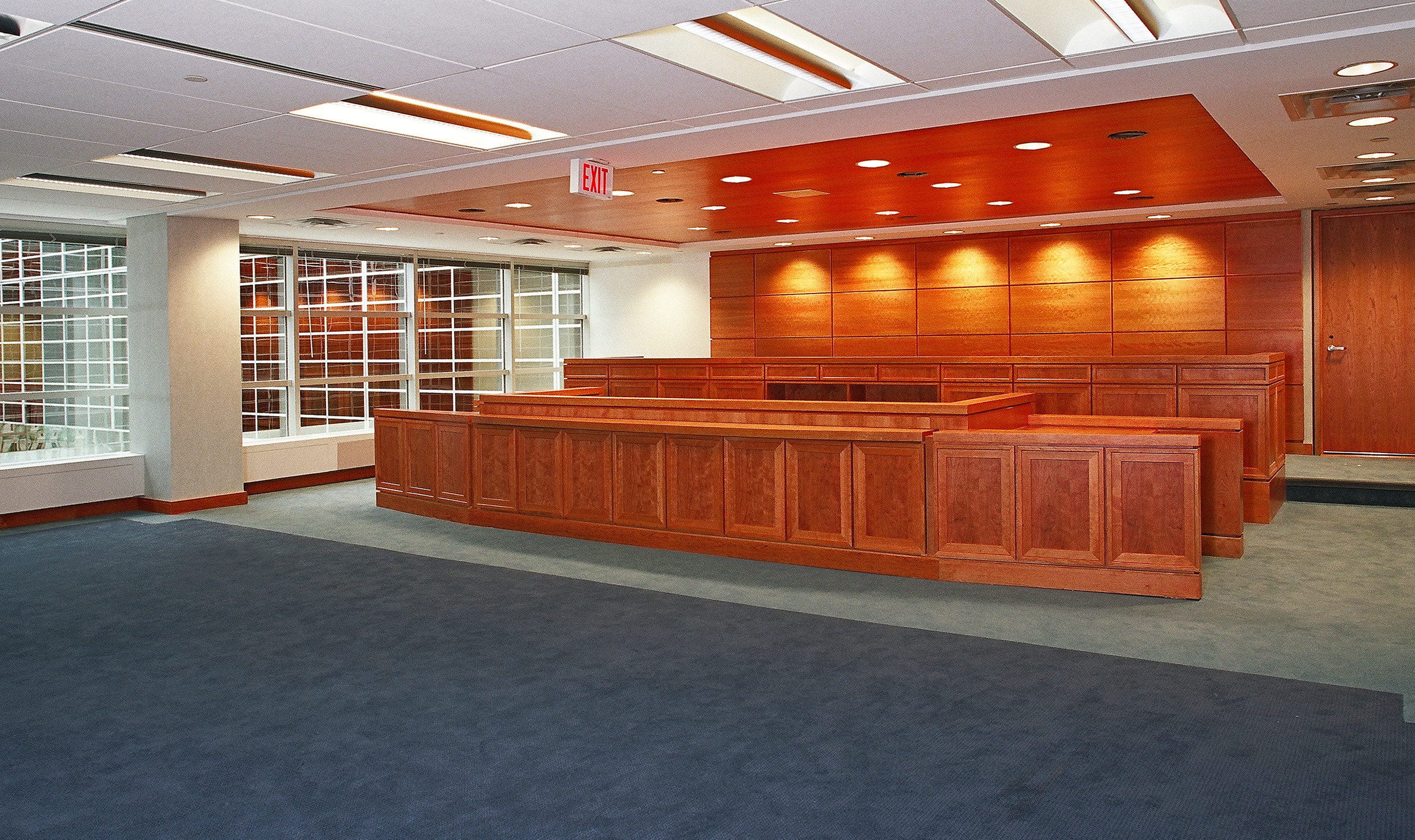 Interior of a spacious room with a wooden bench and a window, highlighting TOFCON's construction project for the Federal Court of Appeals.