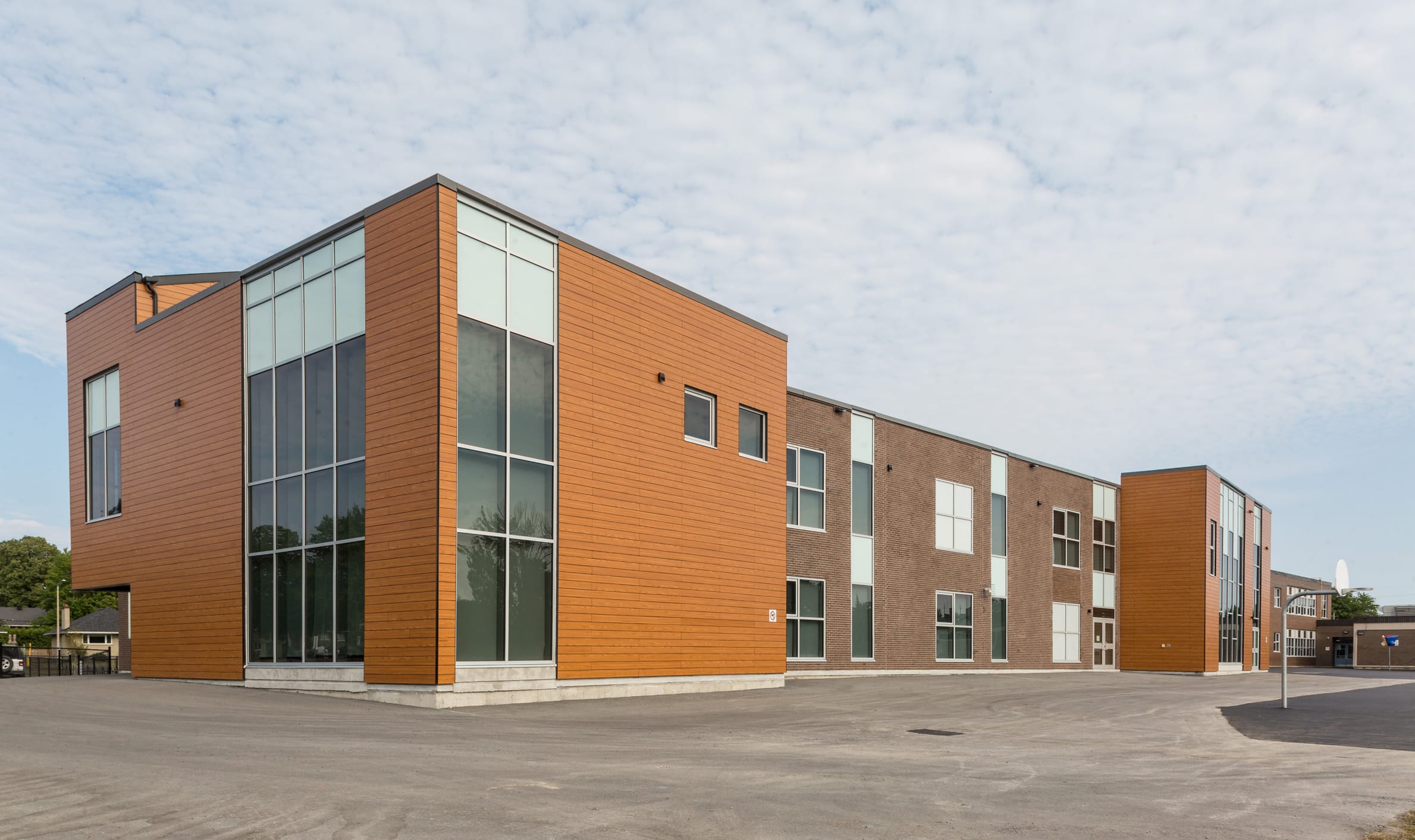 Exterior view of a large building and parking lot, highlighting TOFCON's commercial construction project for Agincourt Public School.