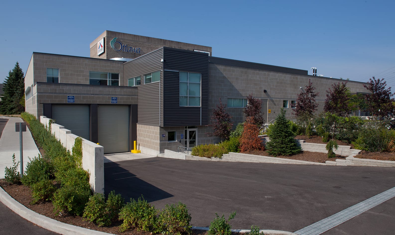 Exterior view of a large building with a significant garage door, showcasing TOFCON's project for Centrepoint Studio Theatre, Ottawa.