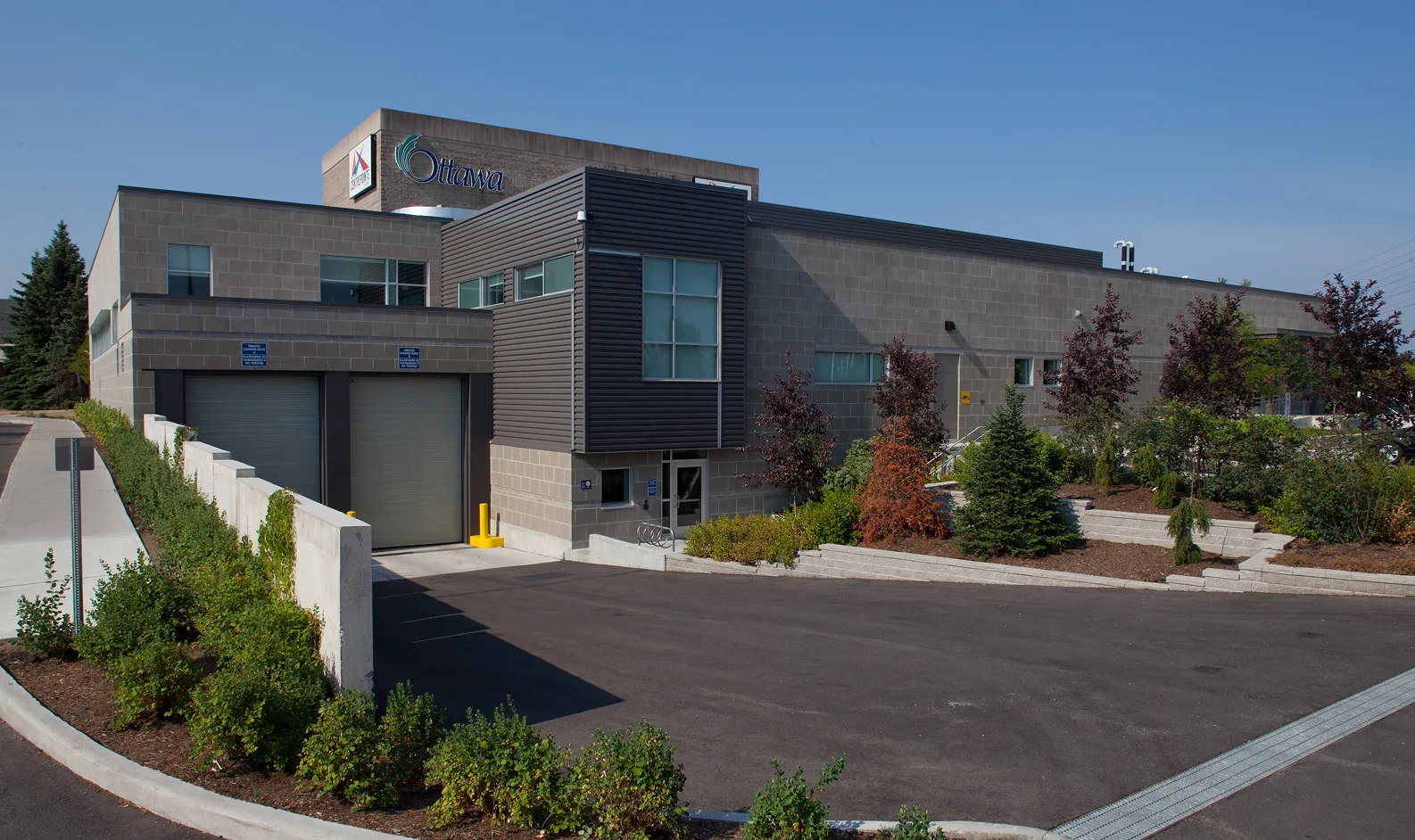 Exterior view of a large building with a significant garage door, showcasing TOFCON's project for Centrepoint Studio Theatre, Ottawa.